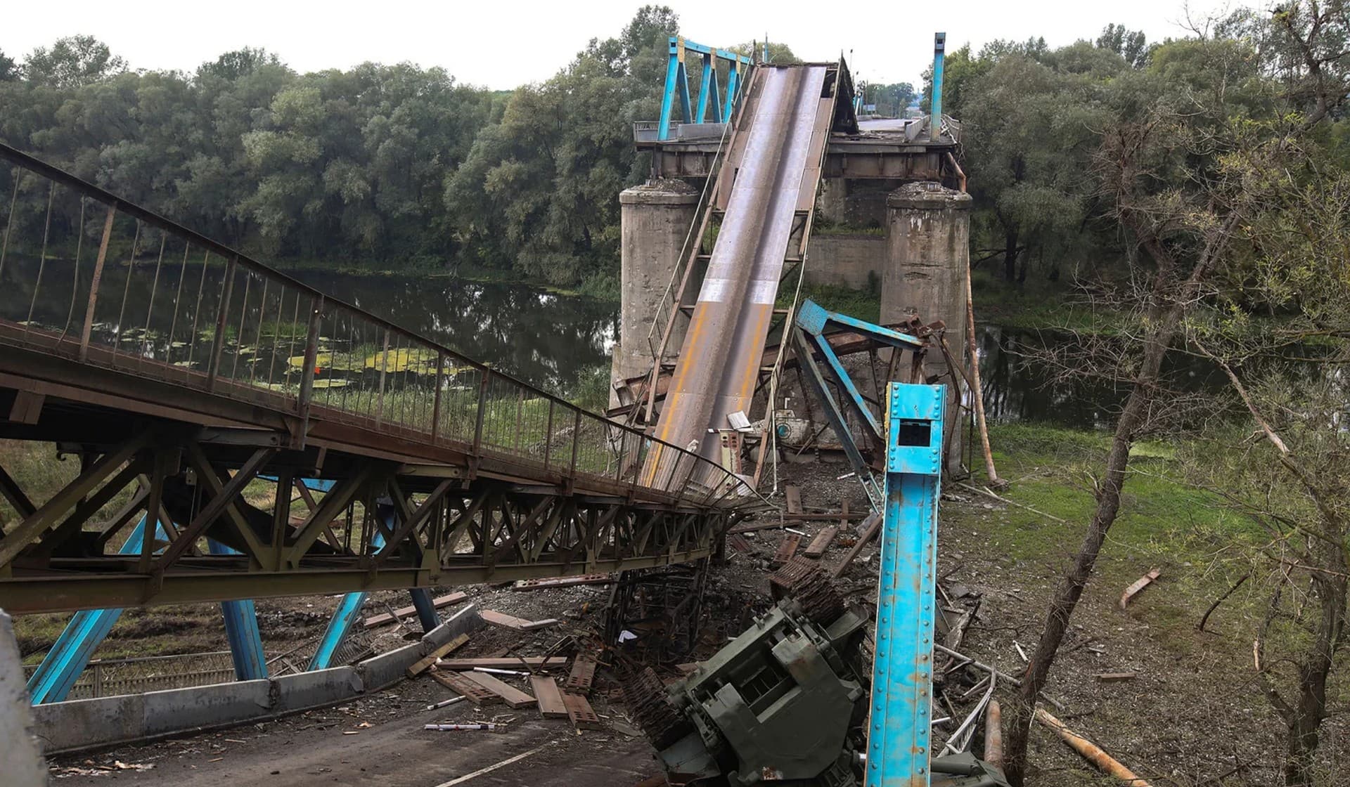 A military vehicle near a destroyed bridge over the Siverskyi Donets River in the town of Izium