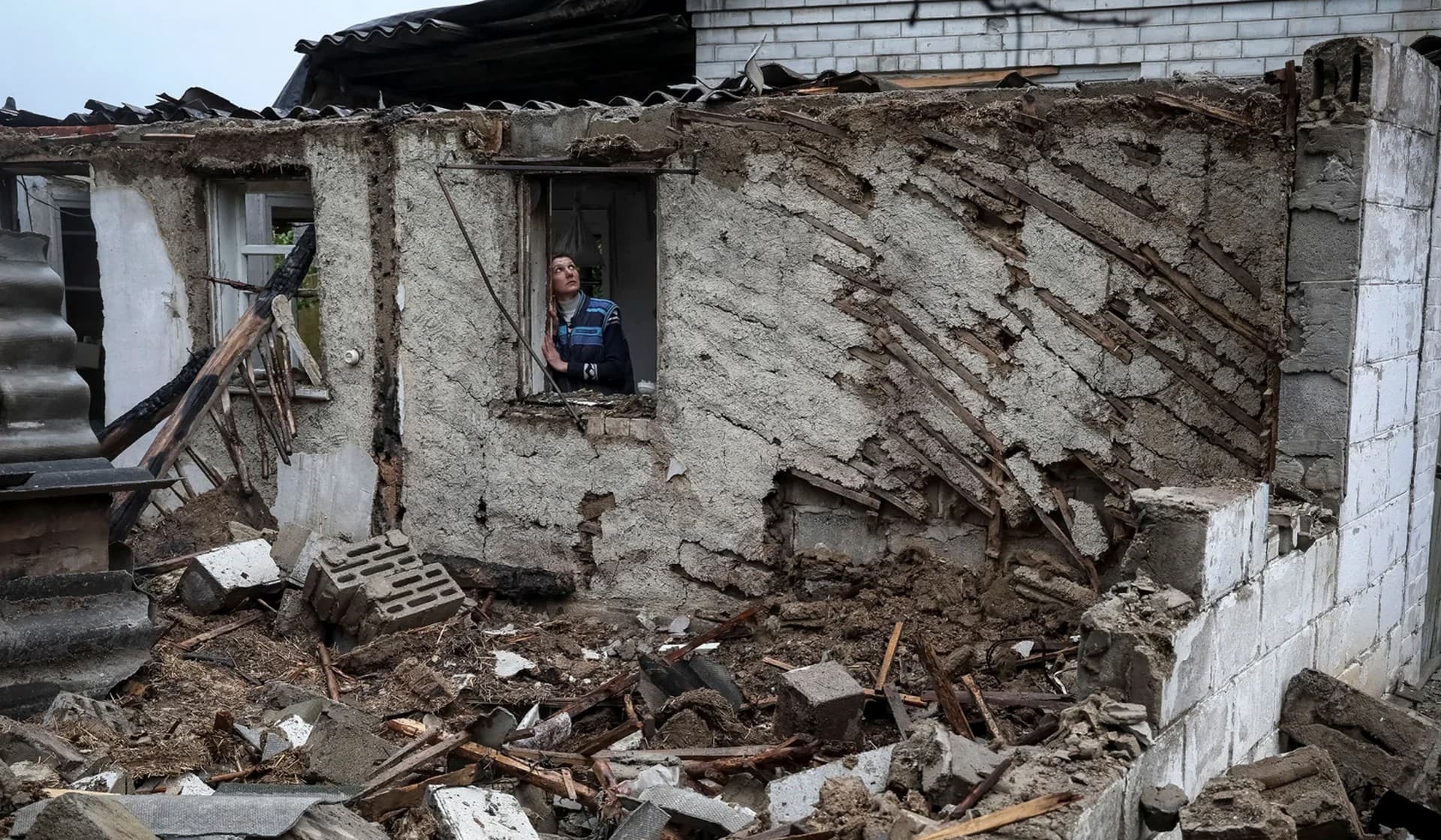 Local resident Olha Nemashkina stands near her destroyed house in the village of Nova Husarivka