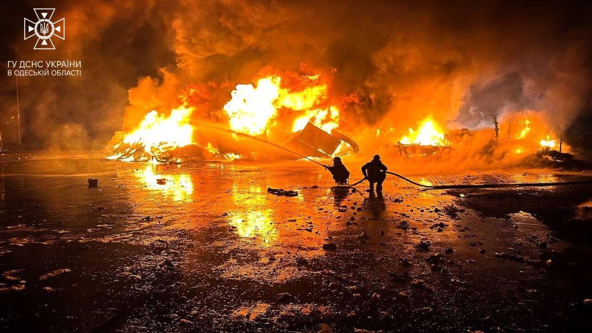 Firefighters work at a compound of a port on Danube river damaged by a Russian drone strike in Odesa region