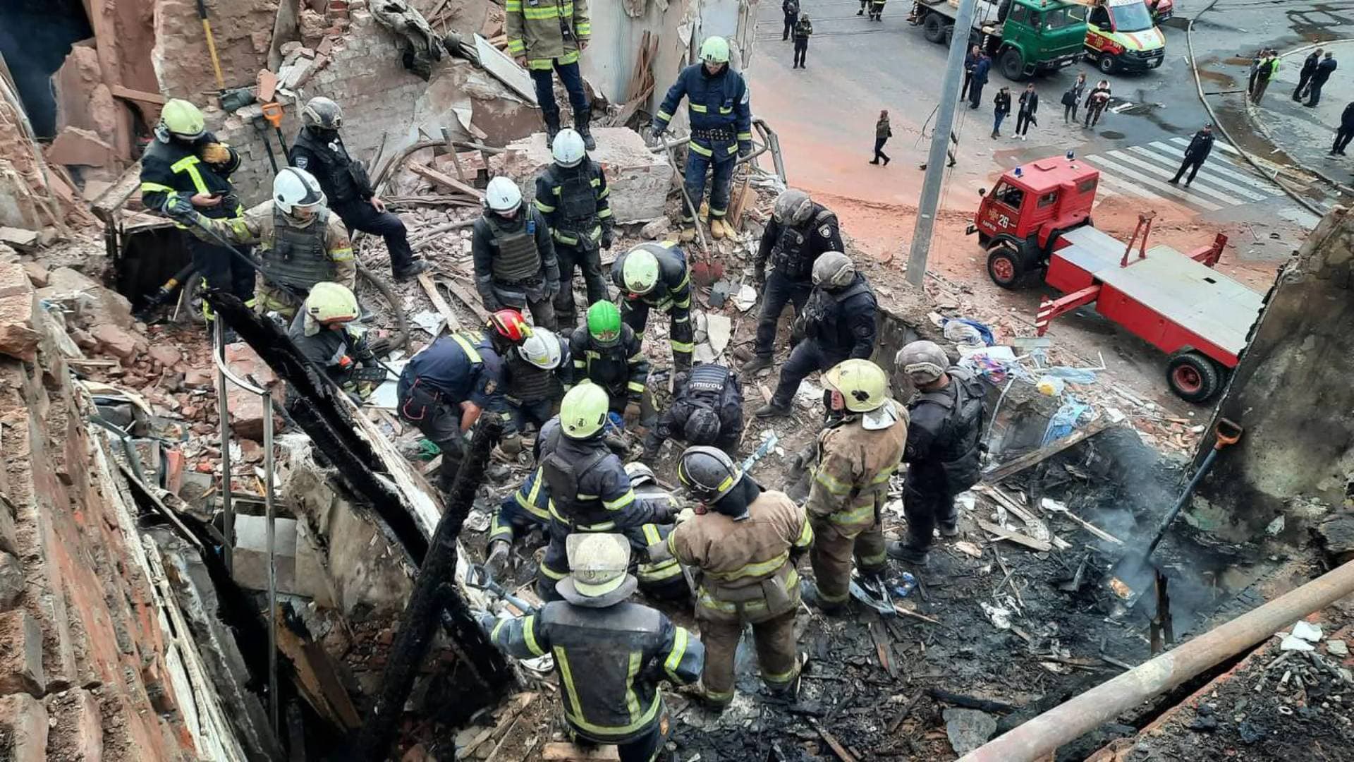 emergency workers search for victims of the Russian rocket attack that damaged a multi-storey building in central Kharkiv