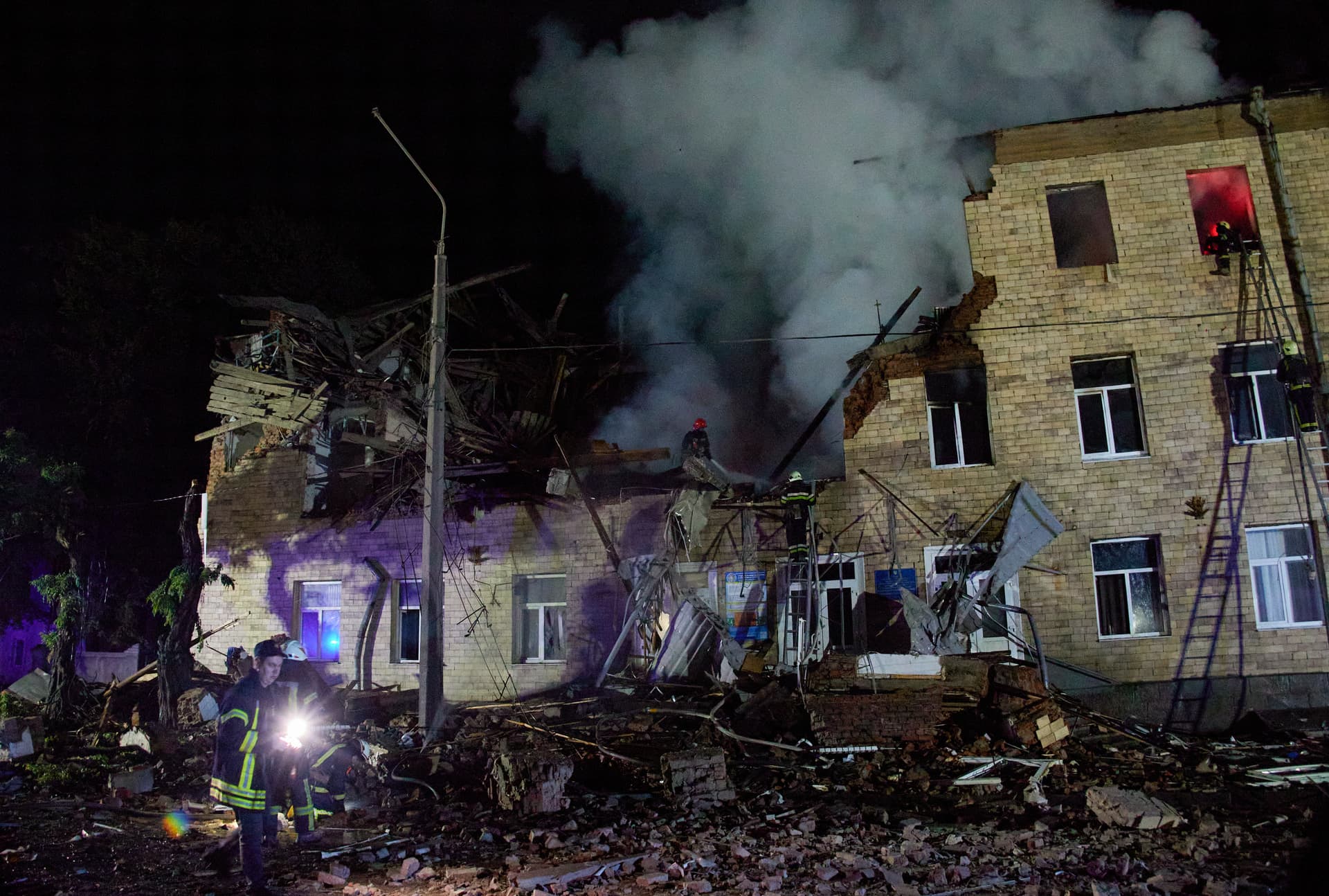 Ukrainian rescuers work at the site of a residential building in Kharkiv