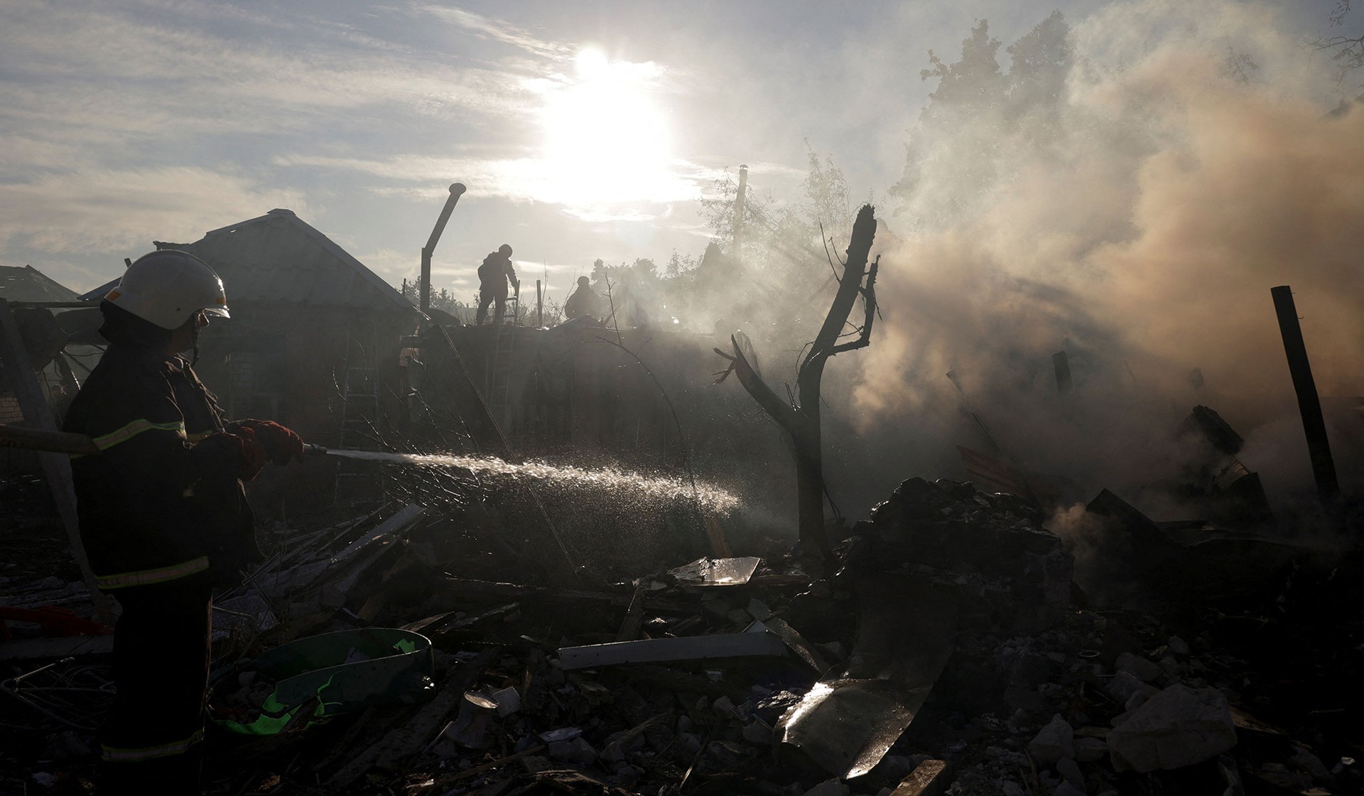 Firefighters work at the site of private houses hit by a Russian air strike in Kharkiv