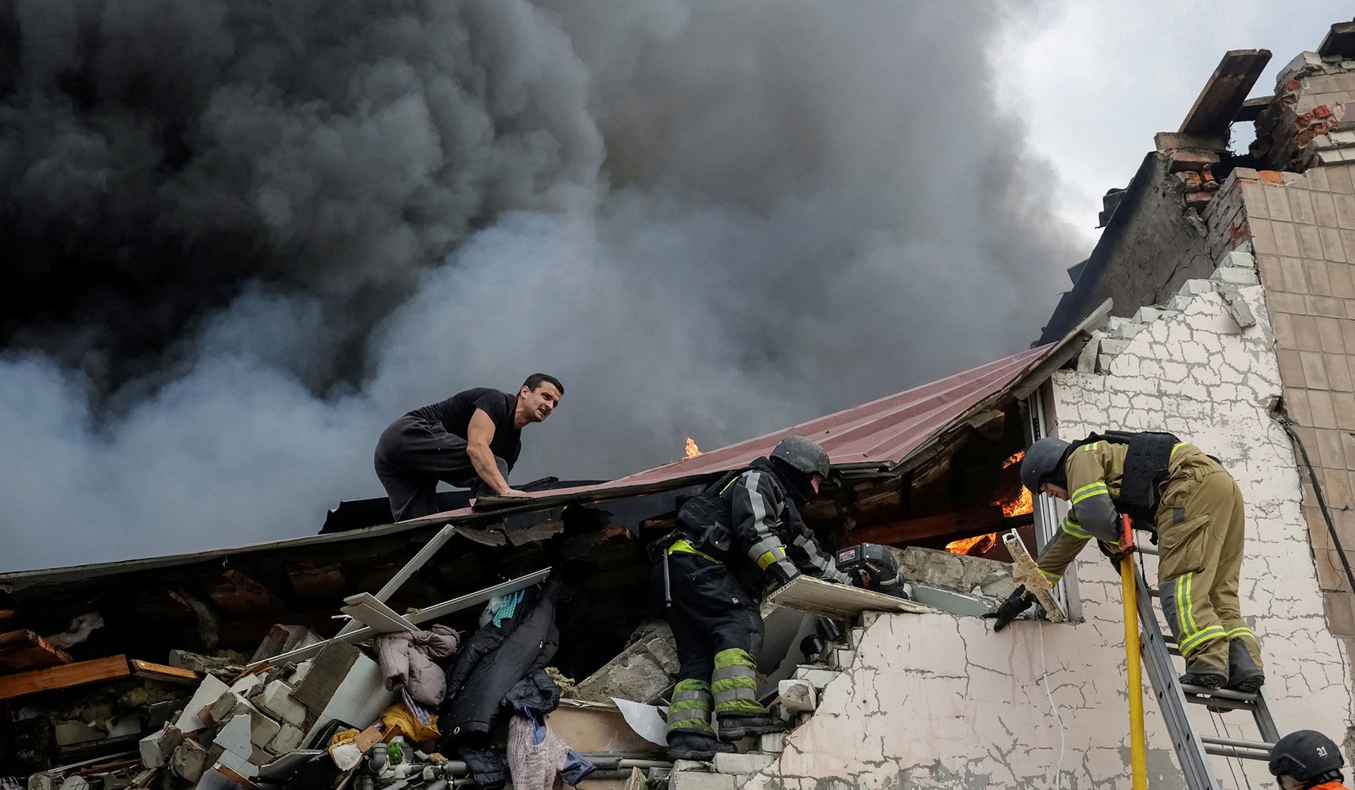 Rescuers work at a site of a building of a sewing factory damaged by a Russian air strike in Kharkiv