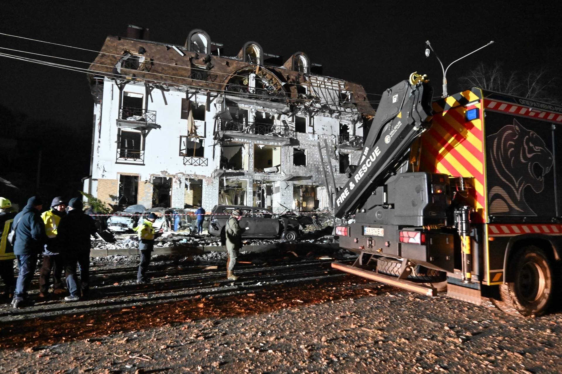 Rescuers cordon off the area surrounding a destroyed hotel following a missile strike in Kharkiv