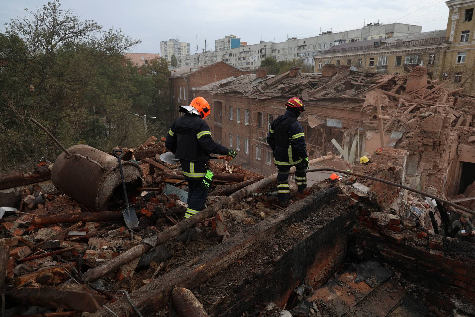 Emergency workers search for victims after a Russian air attack that damaged an apartment building in Kharkiv