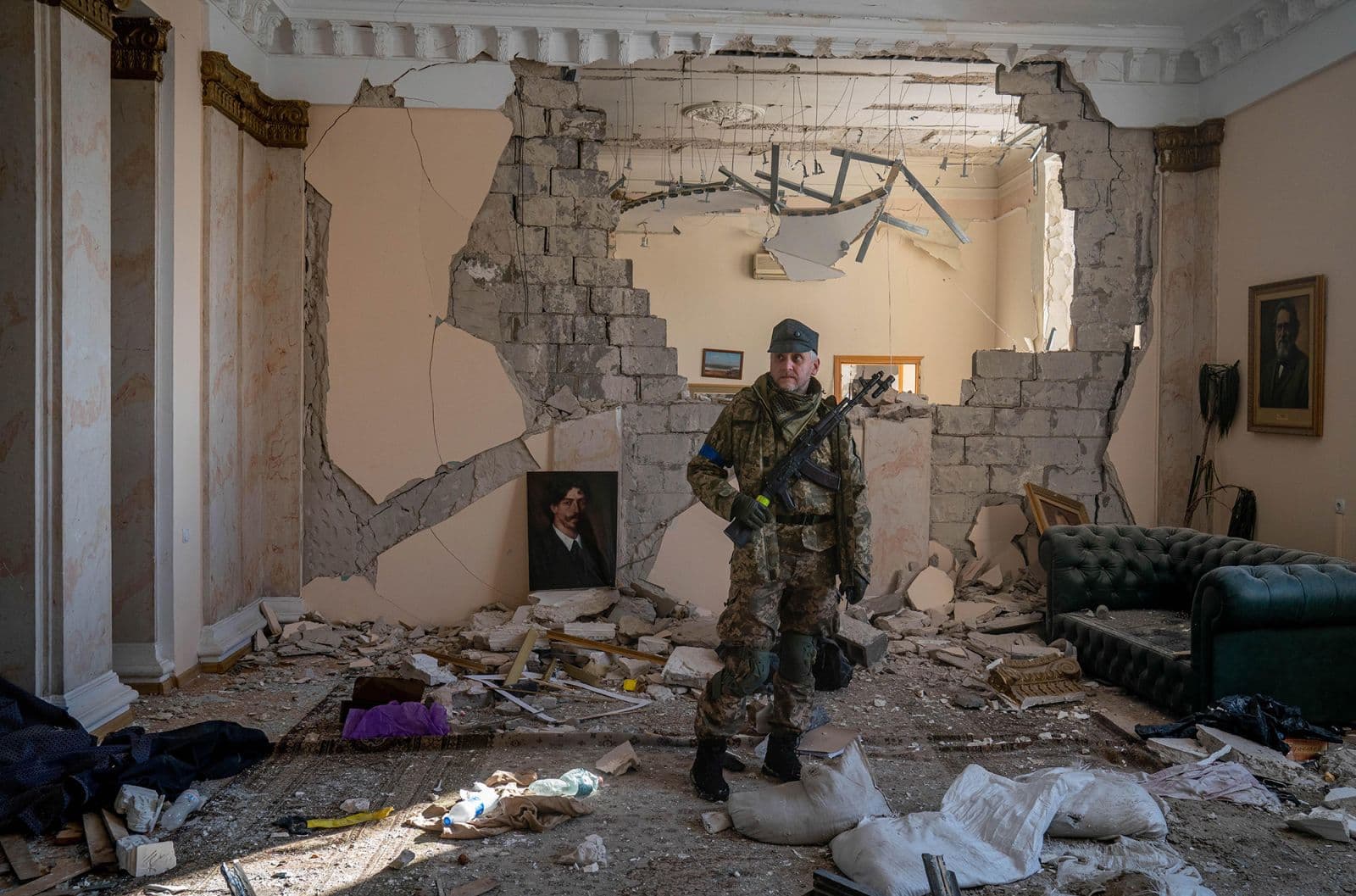 A Ukrainian soldier surveys a destroyed government building in Kharkiv