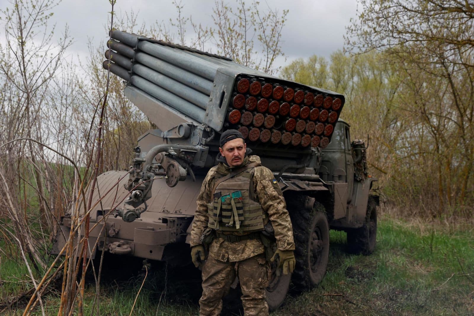 A Ukrainian serviceman stands next to a multiple rocket-launch system in the Kharkiv