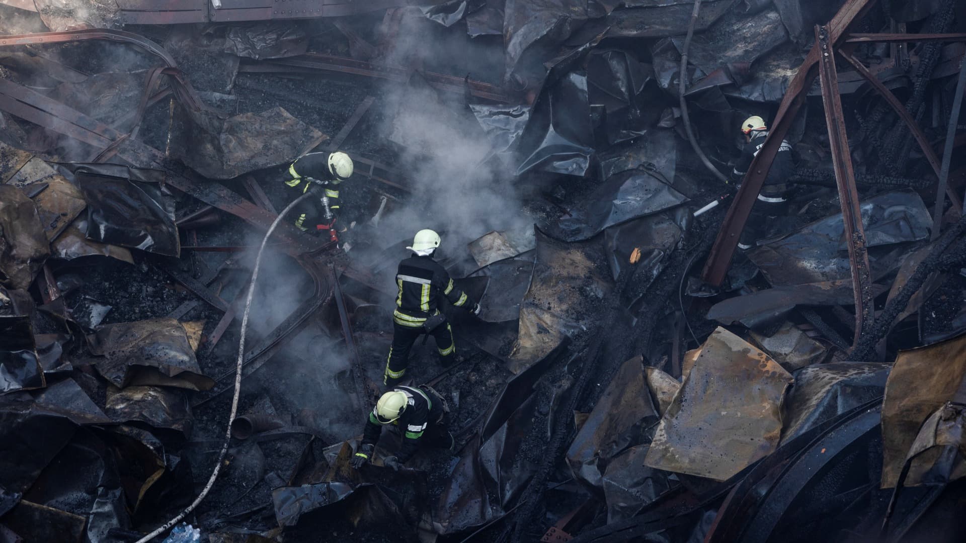 Firefighters work at the site of a House of Culture hit by a Russian missile strike in Kharkiv