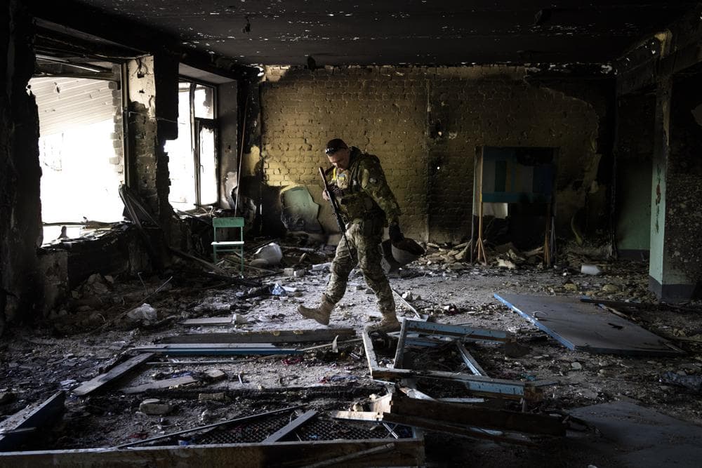 A Ukrainian serviceman inspects a school damaged during a battle between Russian and Ukrainian forces in the village of Vilkhivka, on the outskirts of Kharkiv