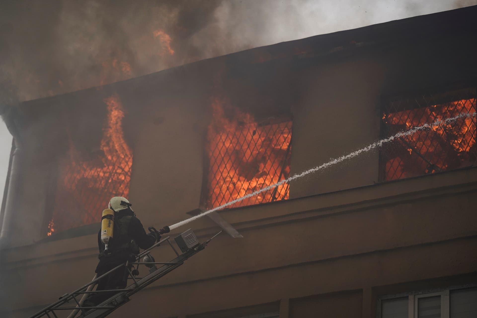 A firefighter works to extinguish a fire after a Russian attack that damaged a police building in Kharkiv