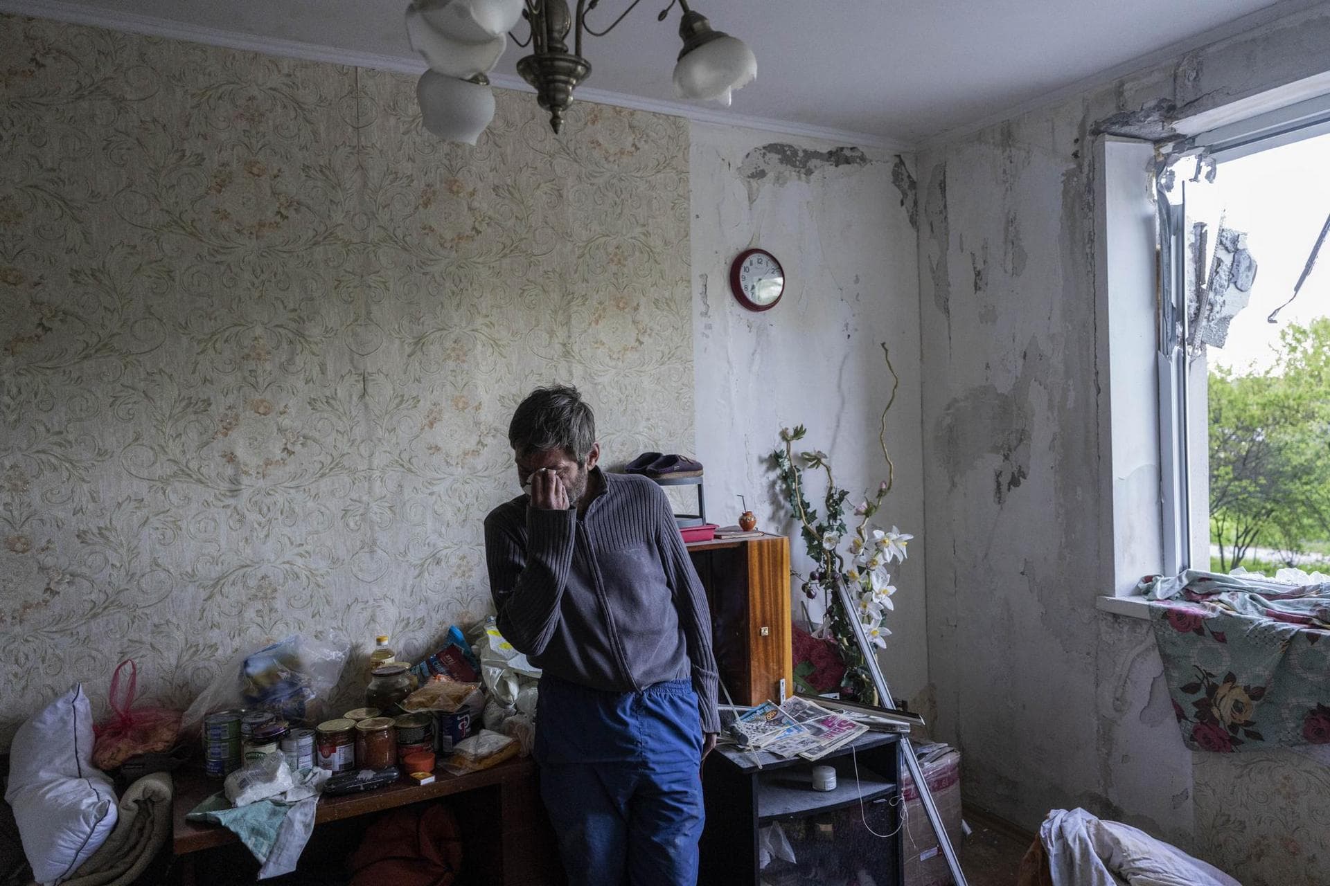 Roman Pryhodchenko cries inside his house damaged by multiple shelling in Kharkiv