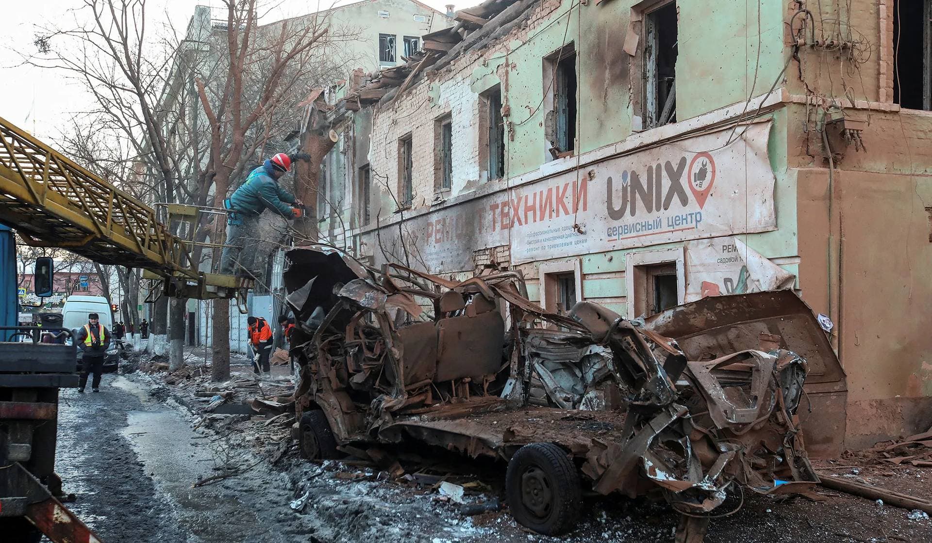 Municipal workers remove debris at a site of a Russian missile strike in central Kharkiv
