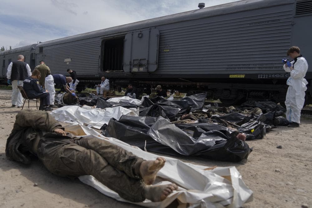 Forensic experts inspect bodies of dead Russian soldiers during an identification process in Kharkiv