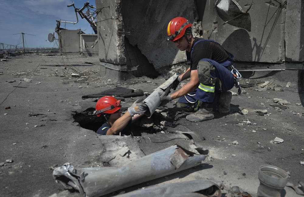 Ukrainian rescuers search for and retrieve the remains of Russian shells on the roof of a high-rise building damaged by Russian shelling in one of the residential areas of Kharkiv