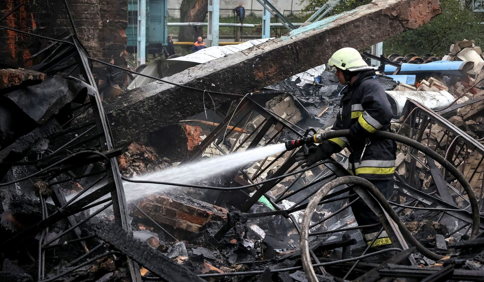 A Ukrainian firefighter work at a freight railway station destroyed by a Russian military strike in Kharkiv