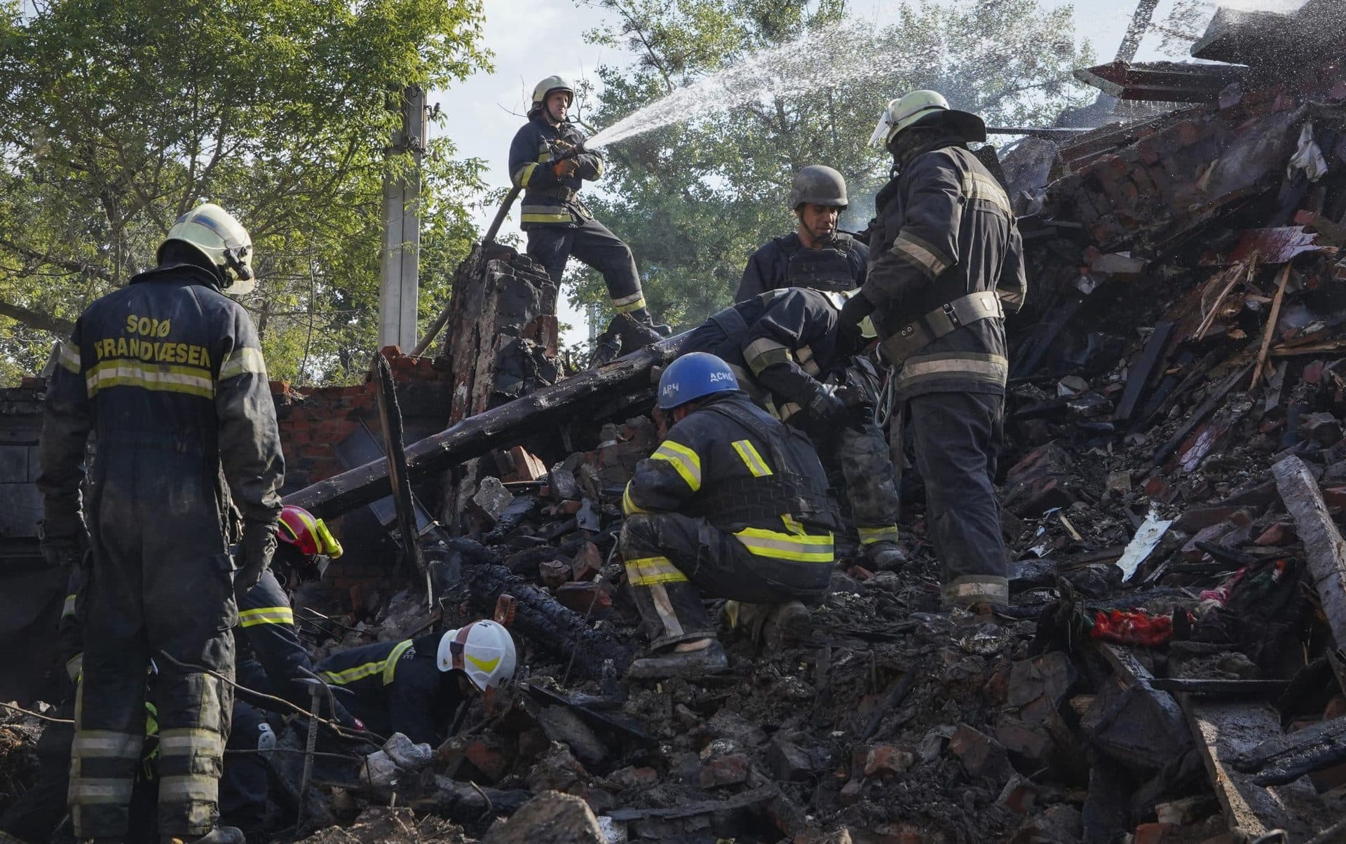 Firefighters dig through the rubble of a building destroyed during a missile strike in Kharkiv