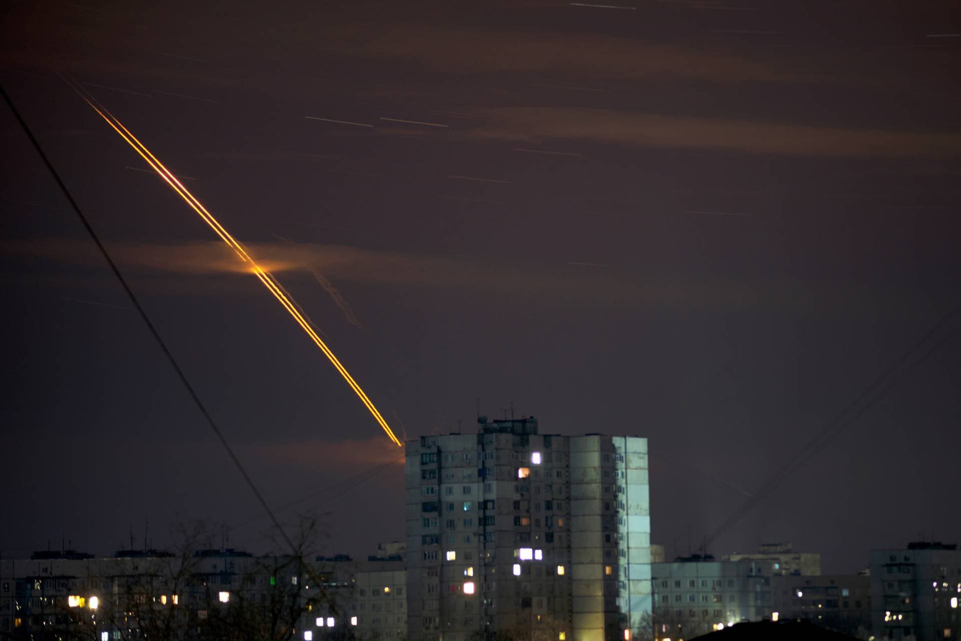 Russian rockets launched against Ukraine from Russia's Belgorod region streak across the sky at dawn in Kharkiv
