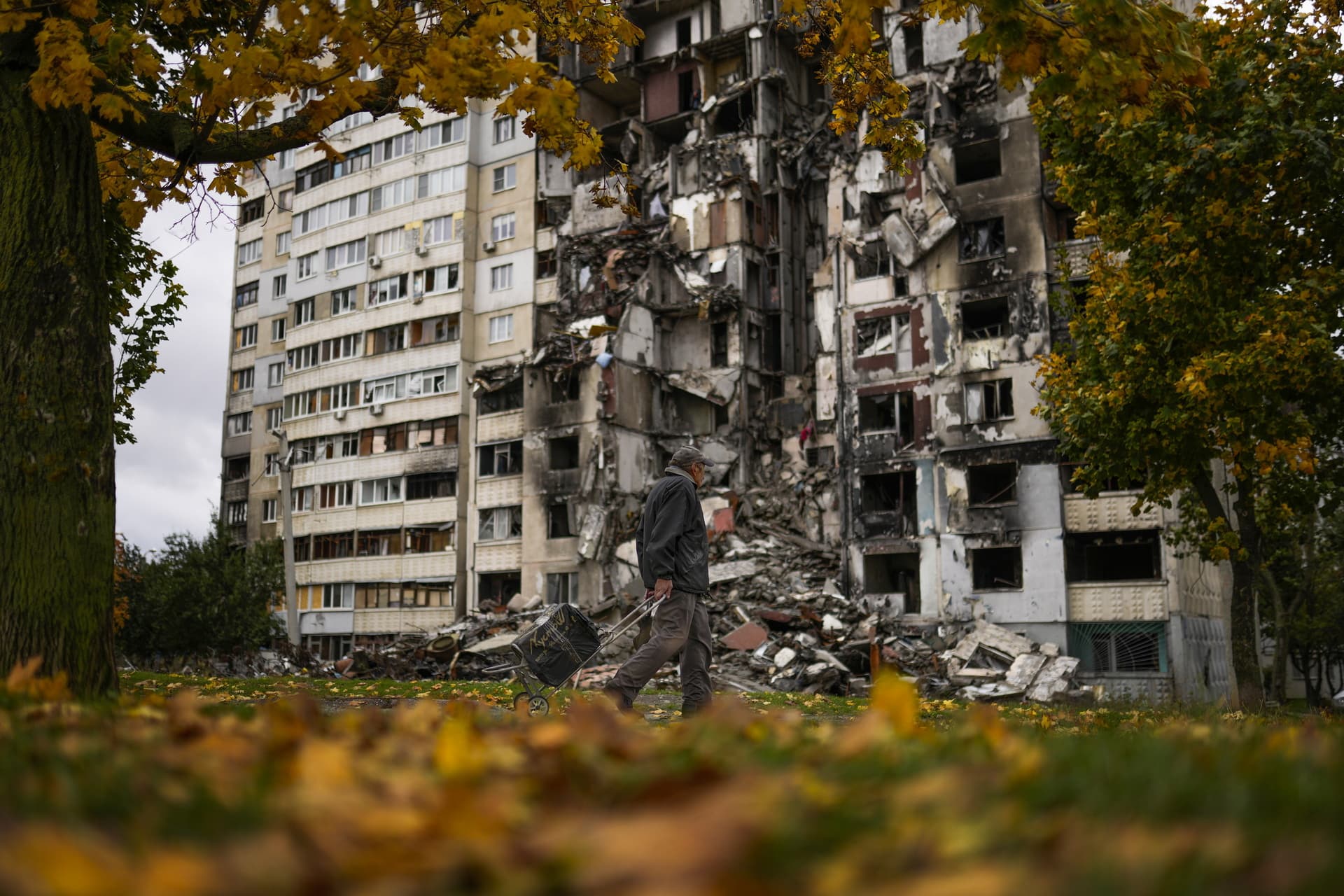 A man walks past a partially destroyed residential building at Saltivka neighbourhood in Kharkiv