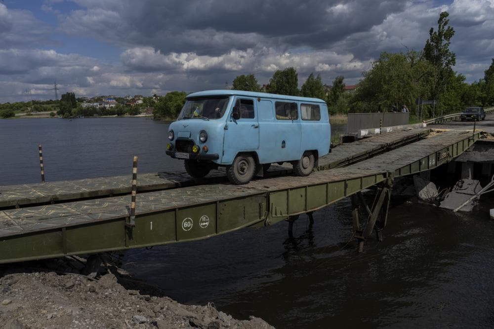 A van drives across a bridge repaired in Vilkhivka, outside Kharkiv