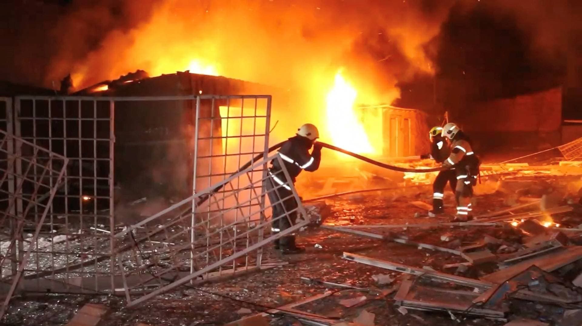 Emergency personnel work to put out a fire following a drone attack in Kharkiv