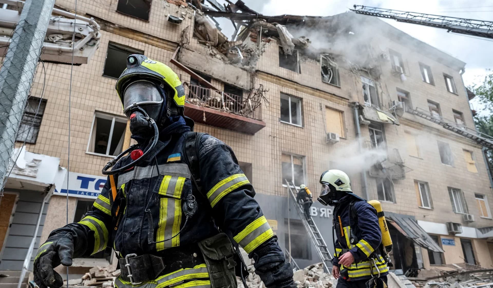 Firefighters work at the site of a residential building hit by a Russian military strike in Kharkiv