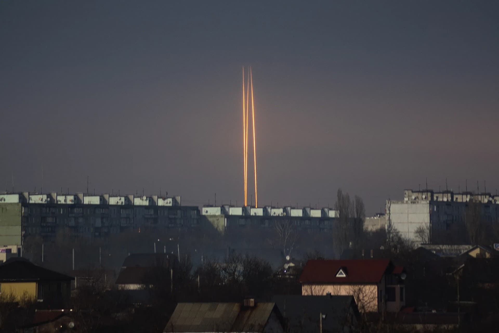 Three rockets launched against Ukraine from Russia's Belgorod region are seen at dawn in Kharkiv