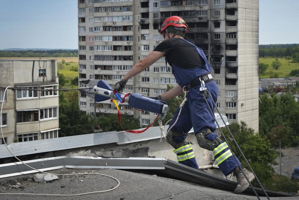 Ukrainian rescuers dismantle the roof of a high-rise building damaged by Russian shelling in one of the residential areas of Kharkiv