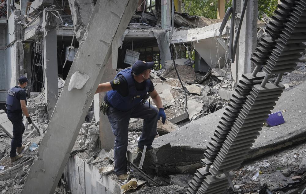 Ukrainian Emergency Situations Ministry employees search the site of a bombing in the school in Kharkiv