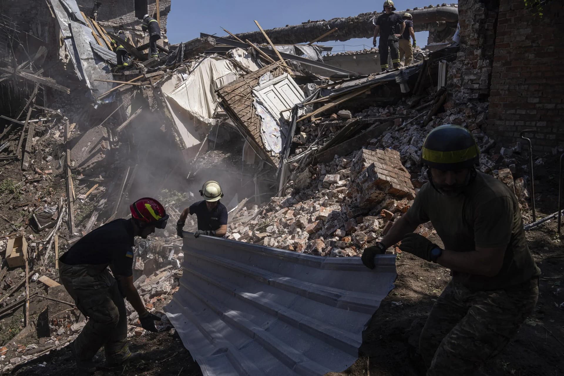 Rescue workers clearing rubble of destroyed house after a Russian attack in a residential neighborhood in downtown Kharkiv