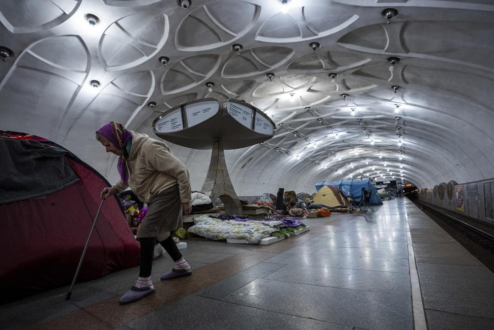 An elderly woman walks inside a metro station being used as a bomb shelter in Kharkiv