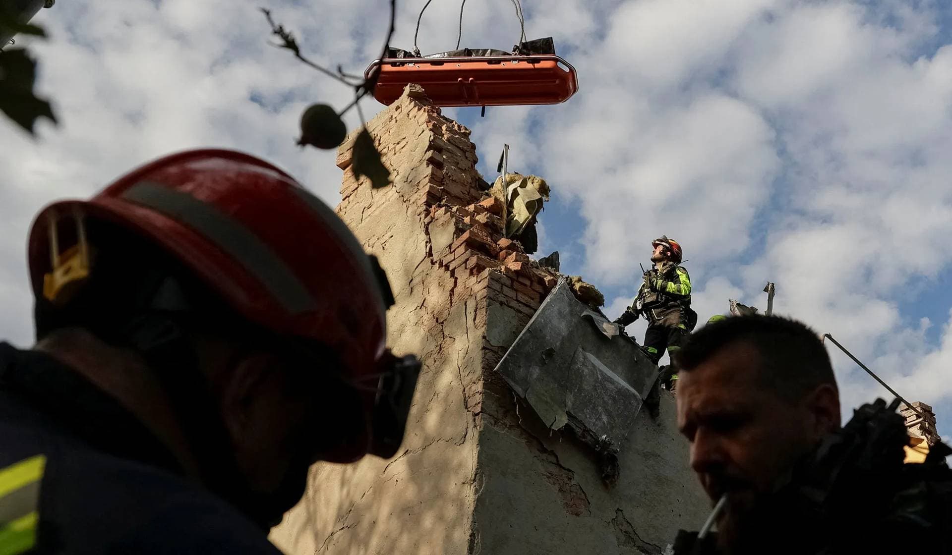 Rescuers use a crane to carry the bodies of people found under debris of an apartment building which was hit by a Russian air strike in Kharkiv