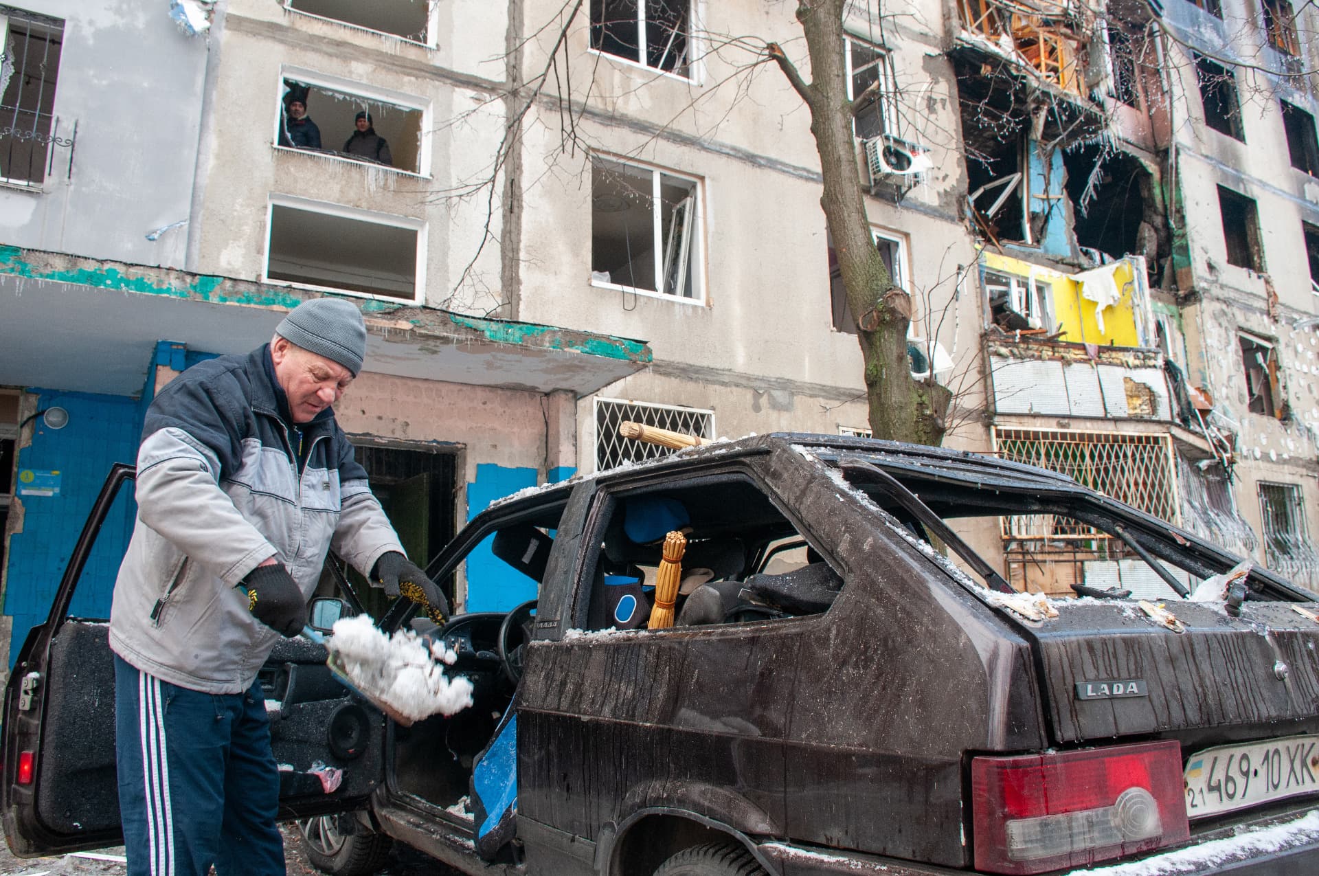 A man near a car wrecked after shelling by the Russian military-occupiers in Kharkiv