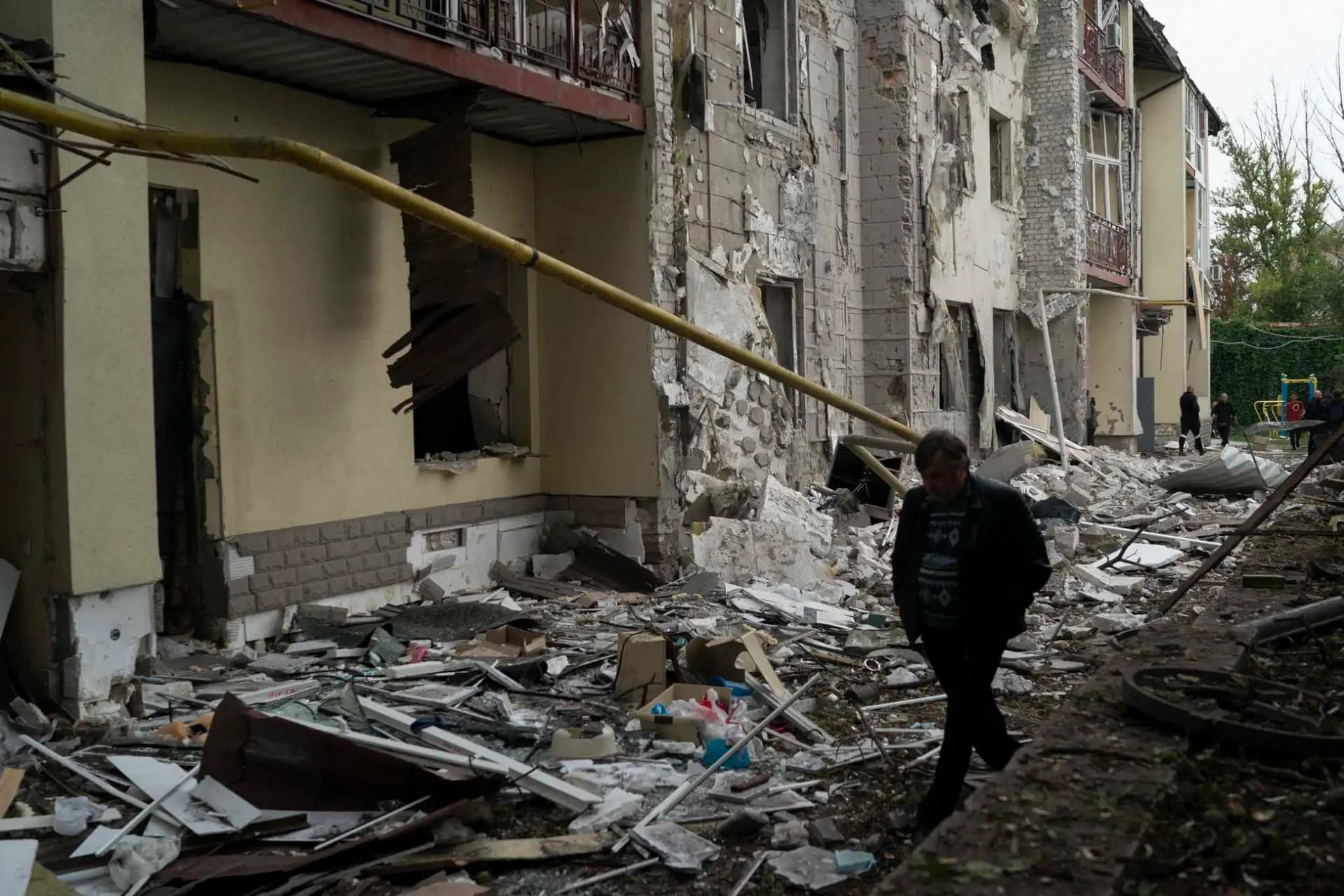 A man walks over debris of a residential building that was damaged after a Russian attack in Kharkiv