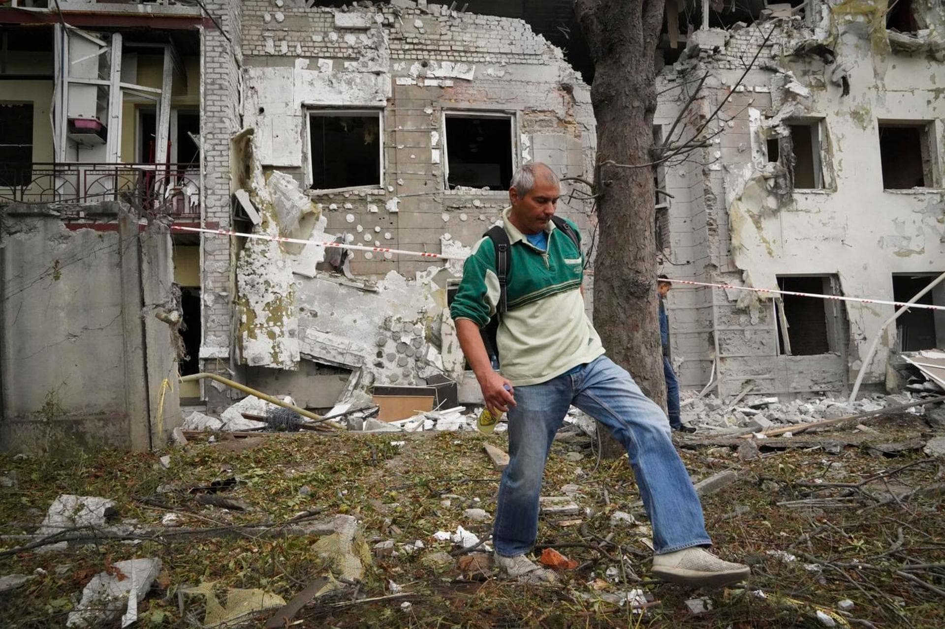 A man passes by destroyed buildings after the latest Russian rocket attack in downtown Kharkiv