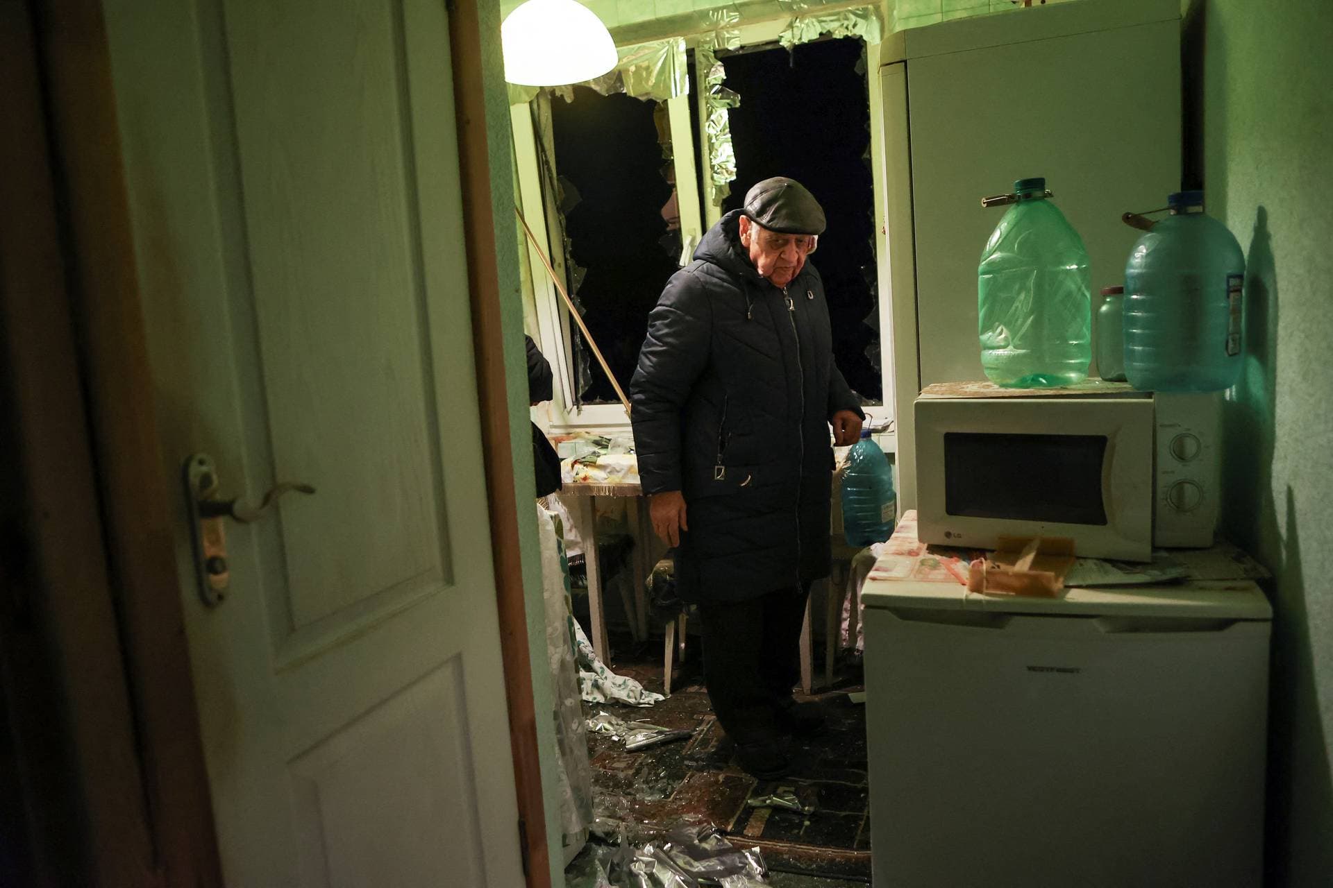 An injured local residents stands in his apartment damaged during a Russian drone strike in Kharkiv