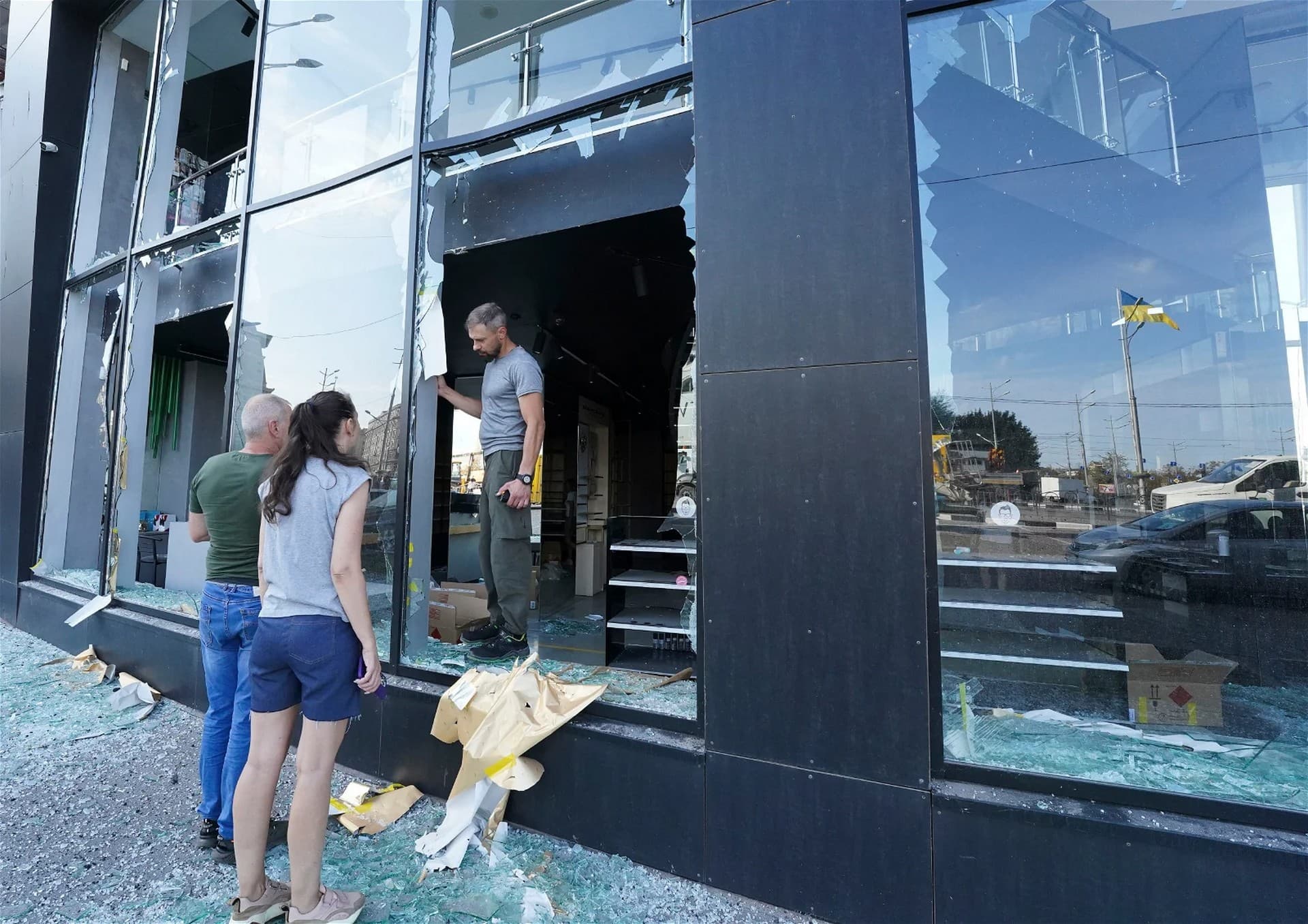Shop owners inspect broken windows after the night Russian rocket attack in downtown Kharkiv