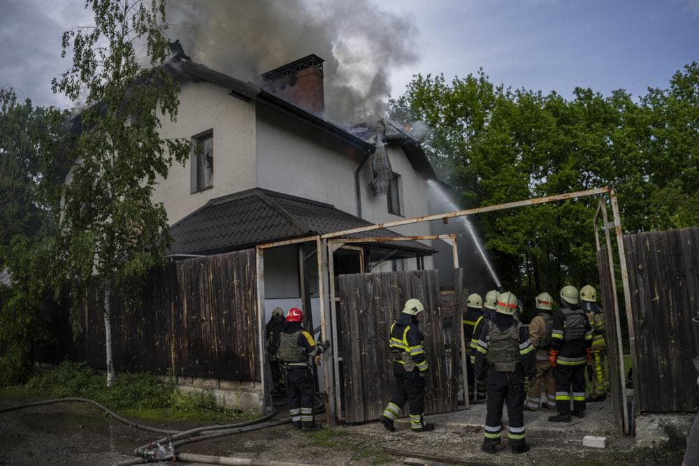 Ukrainian firefighters try to extinguish a fire in a house that was hit during a Russian attack with a cluster-type munition in Kharkiv