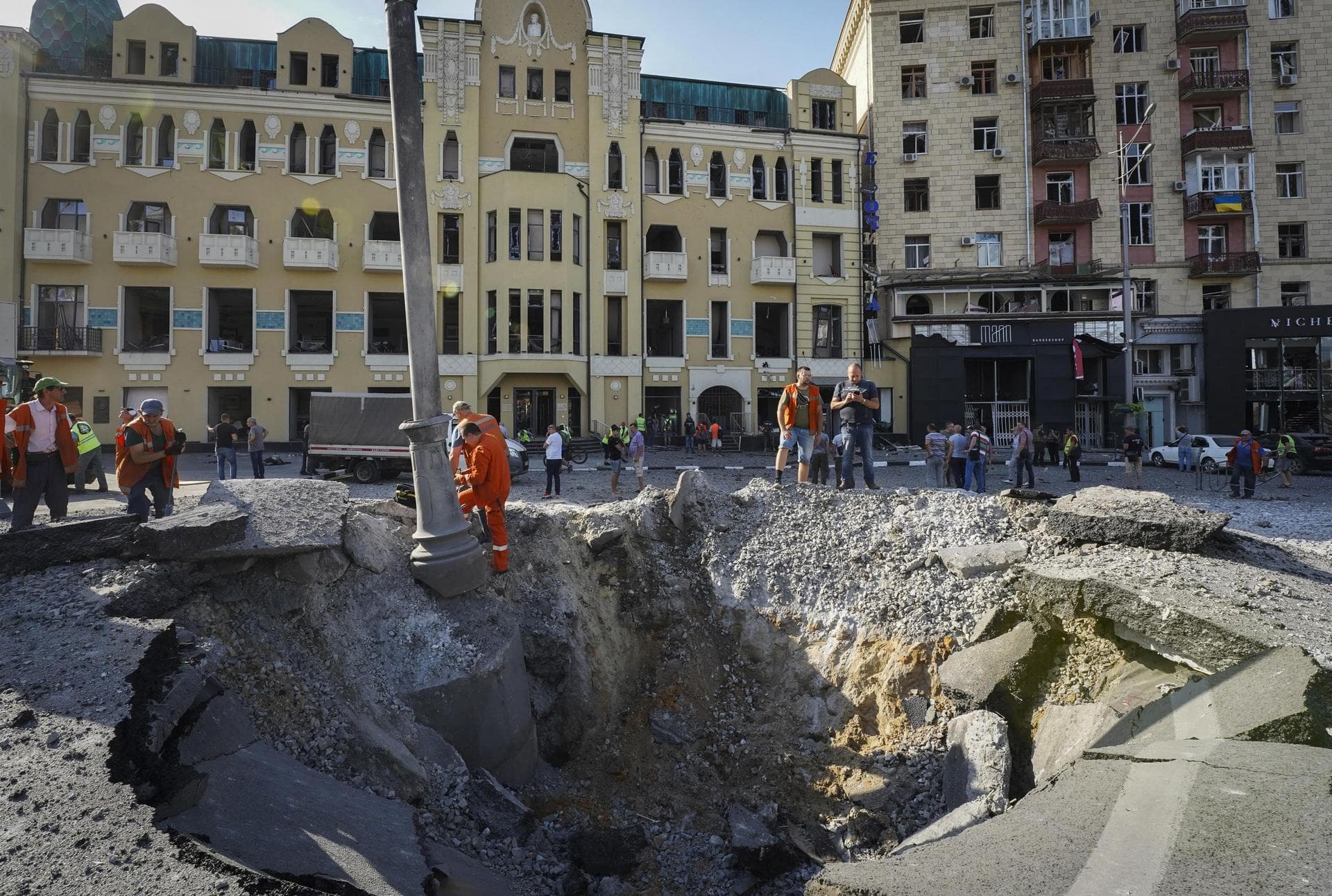 A view of a crater from a night Russian rocket attack, near to damaged buildings in downtown Kharkiv