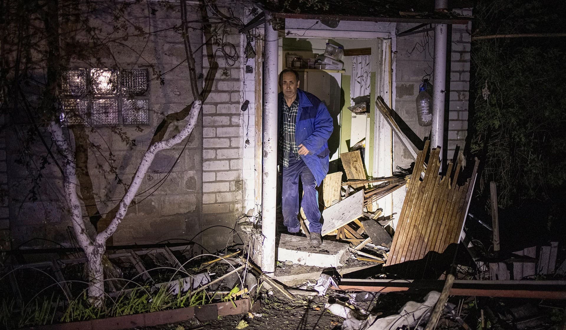 A local resident stands next to his house damaged by a Russian missile strike in the village of Kotliary