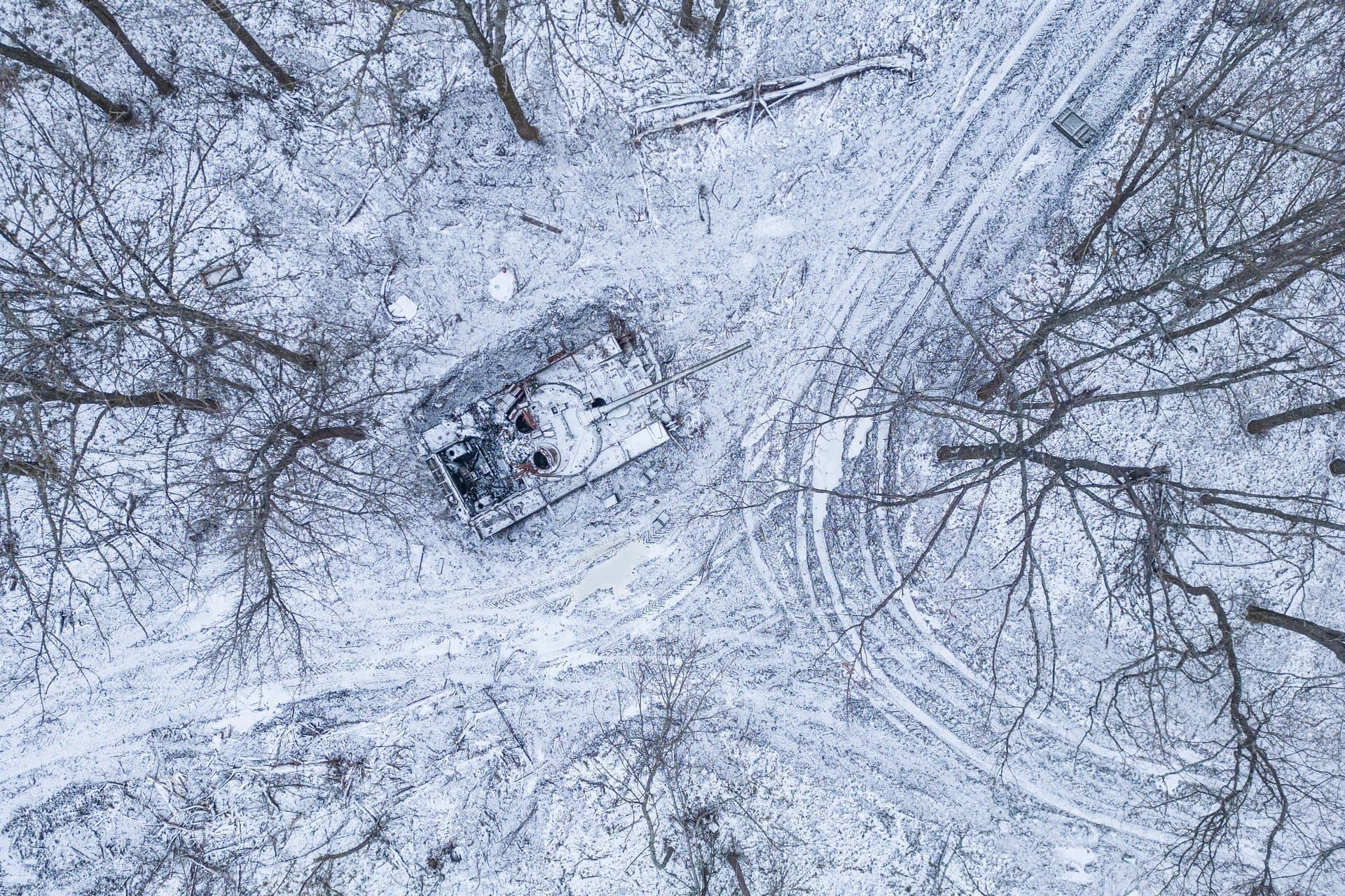 A destroyed Russian tank covered by snow in a forest in the Kharkiv region