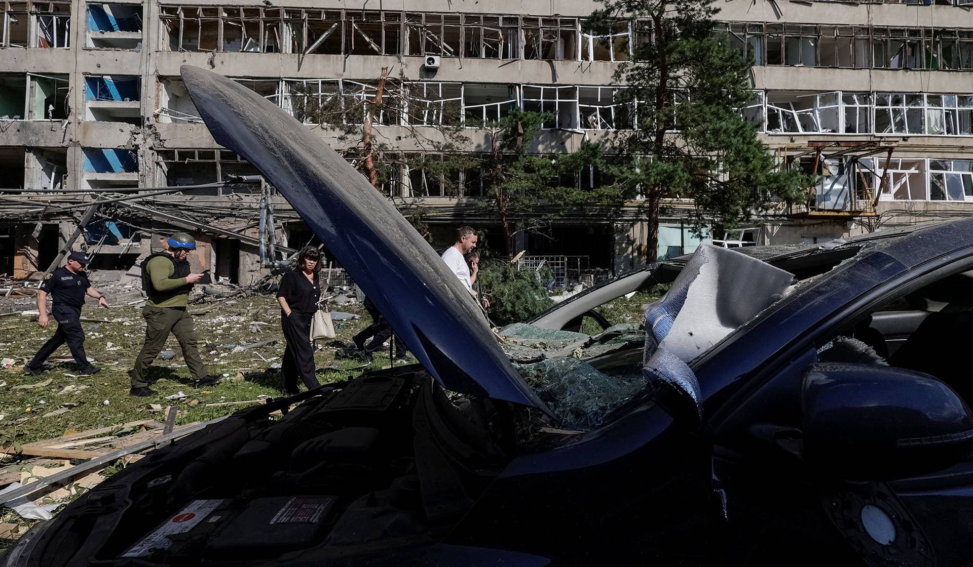 People walk at a site of a Russian air strike in Kharkiv