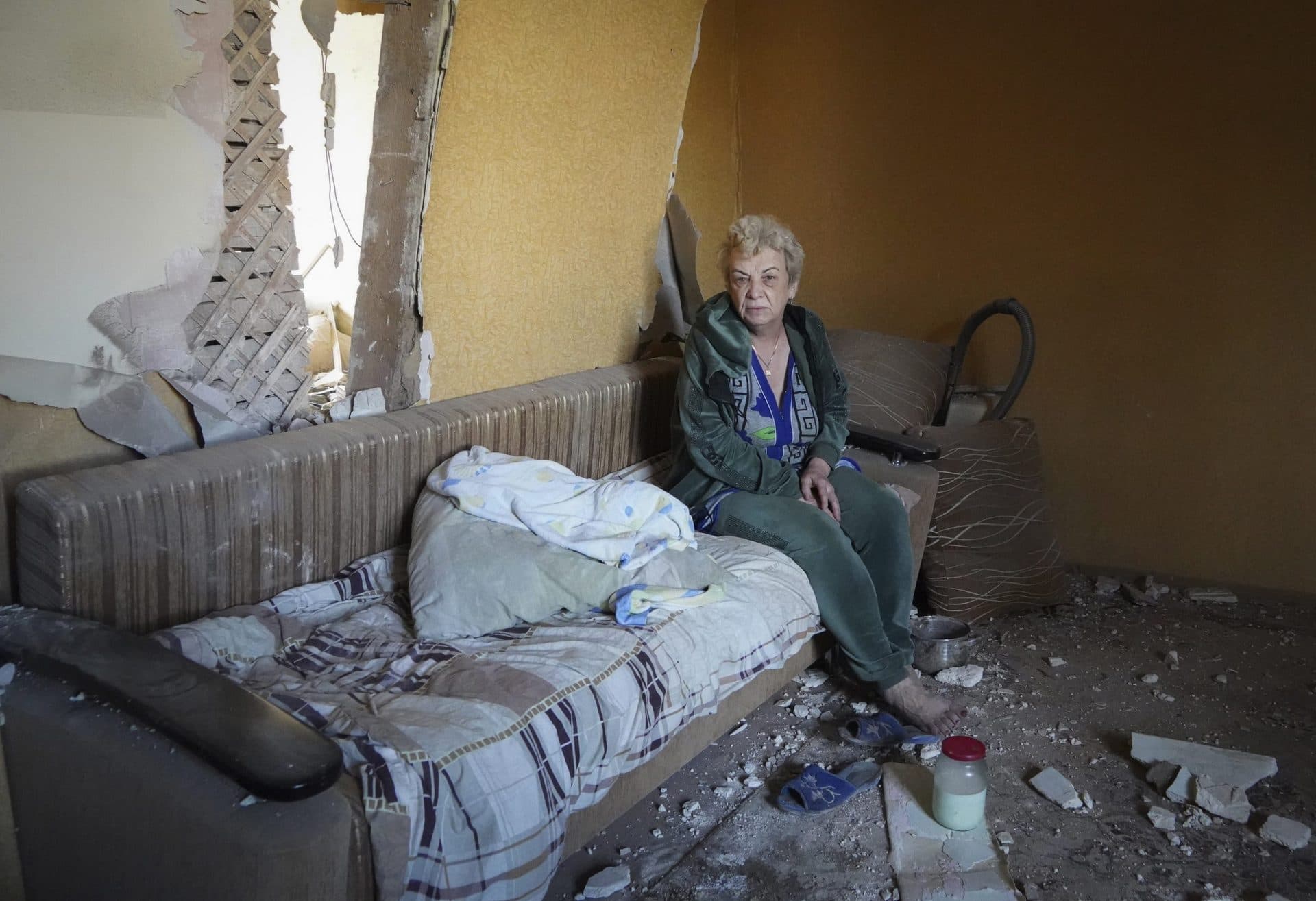 Ukrainian woman sits in her flat at a building destroyed during a missile strike in Kharkiv