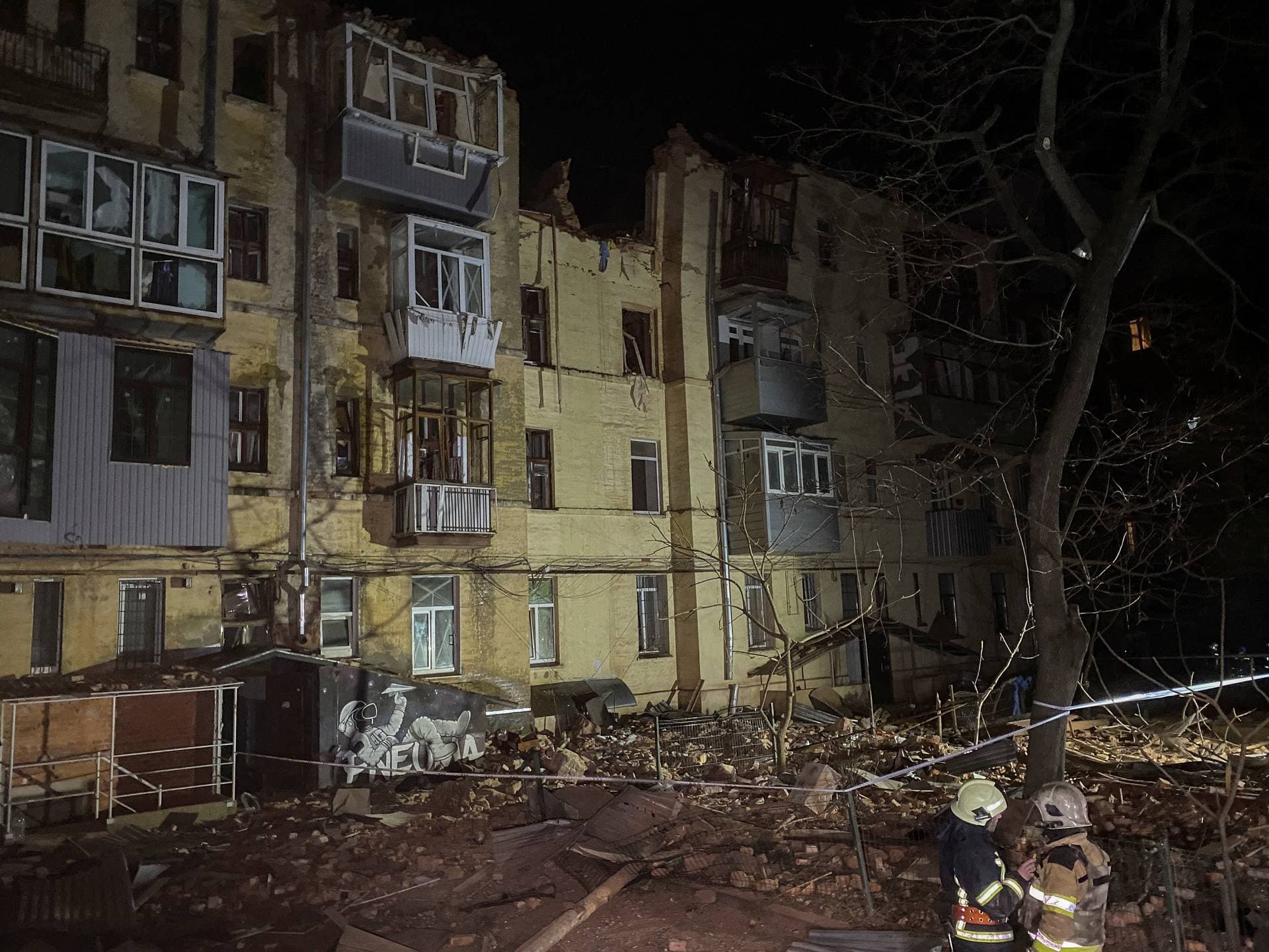 An emergency worker walks in front of a residential building which was hit by a Russian rocket in the city center of Kharkiv