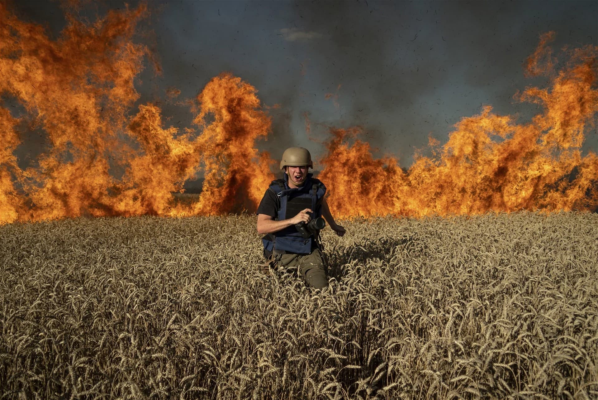 Photojournalist Evgeniy Maloletka runs from the fire in a burning wheat field during