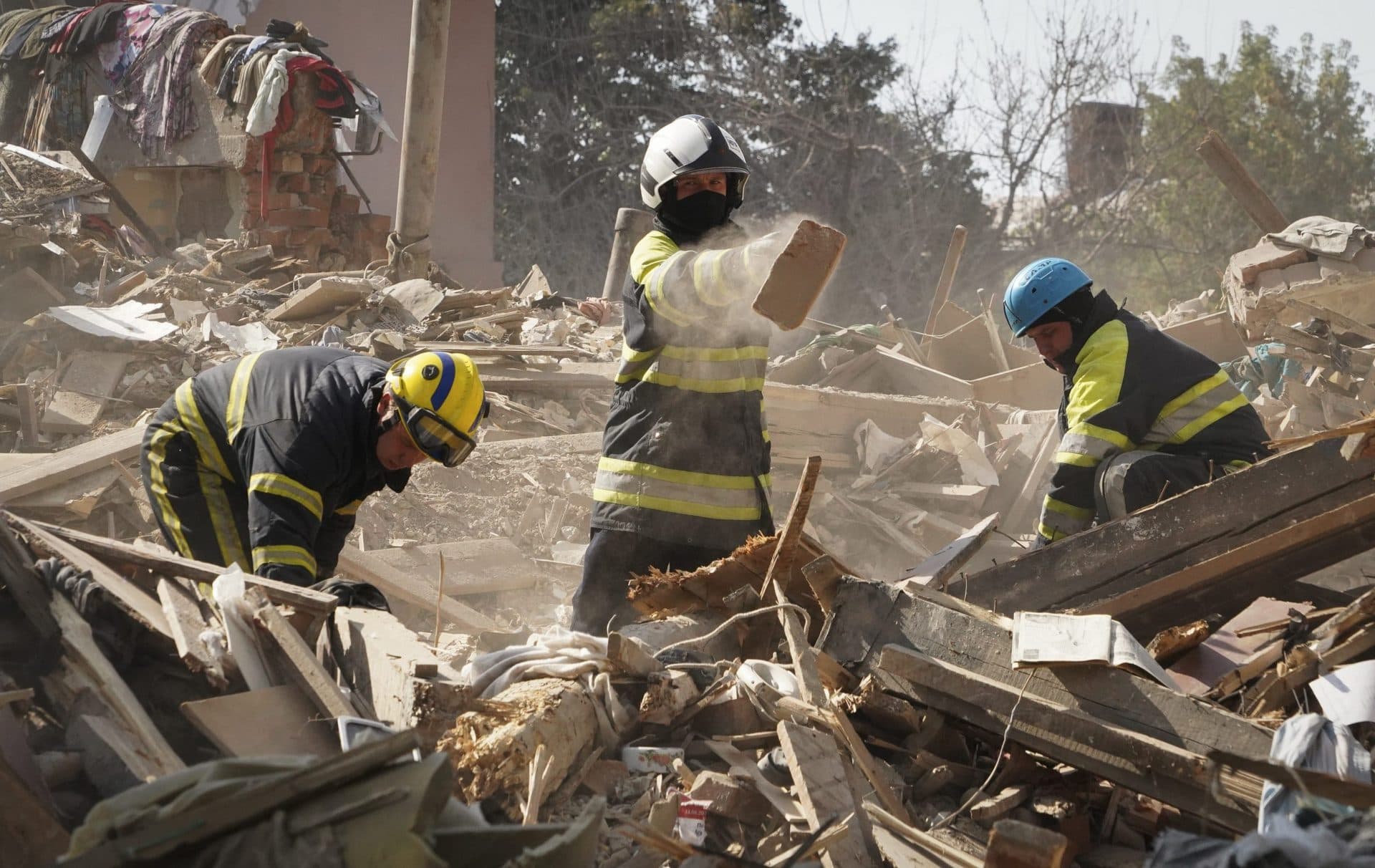 Firefighters dig through the rubble of the building destroyed during a missile strike in Kharkiv