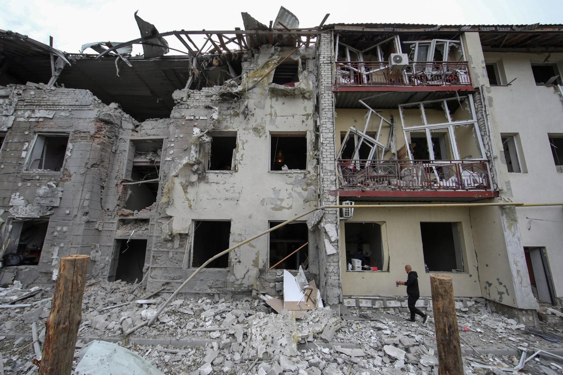 A man walks in a front of a residential building damaged by a Russian missile strike in Kharkiv