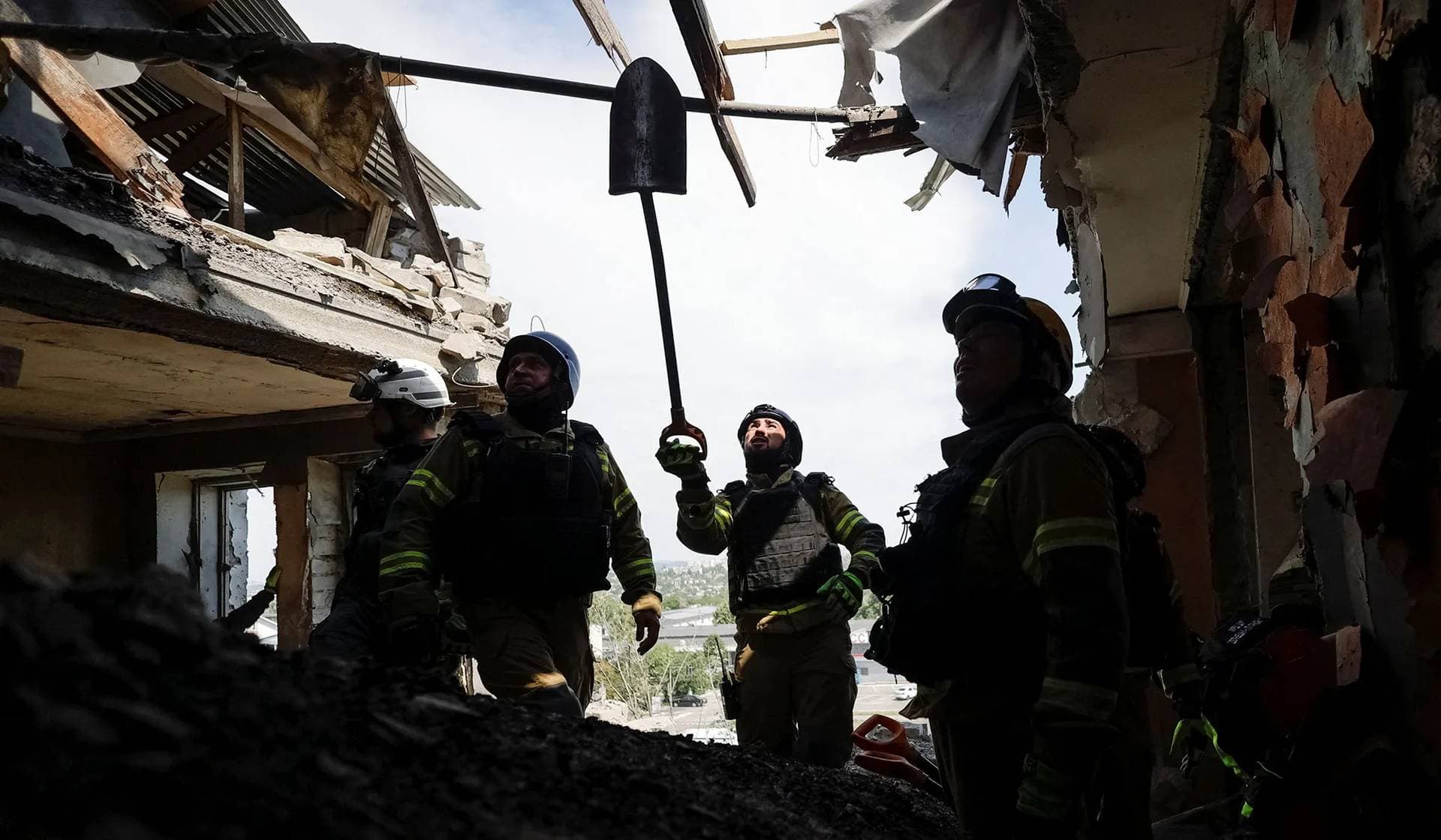 Emergency responders inspect the site of an apartment building hit by a Russian missile strike in Kharkiv