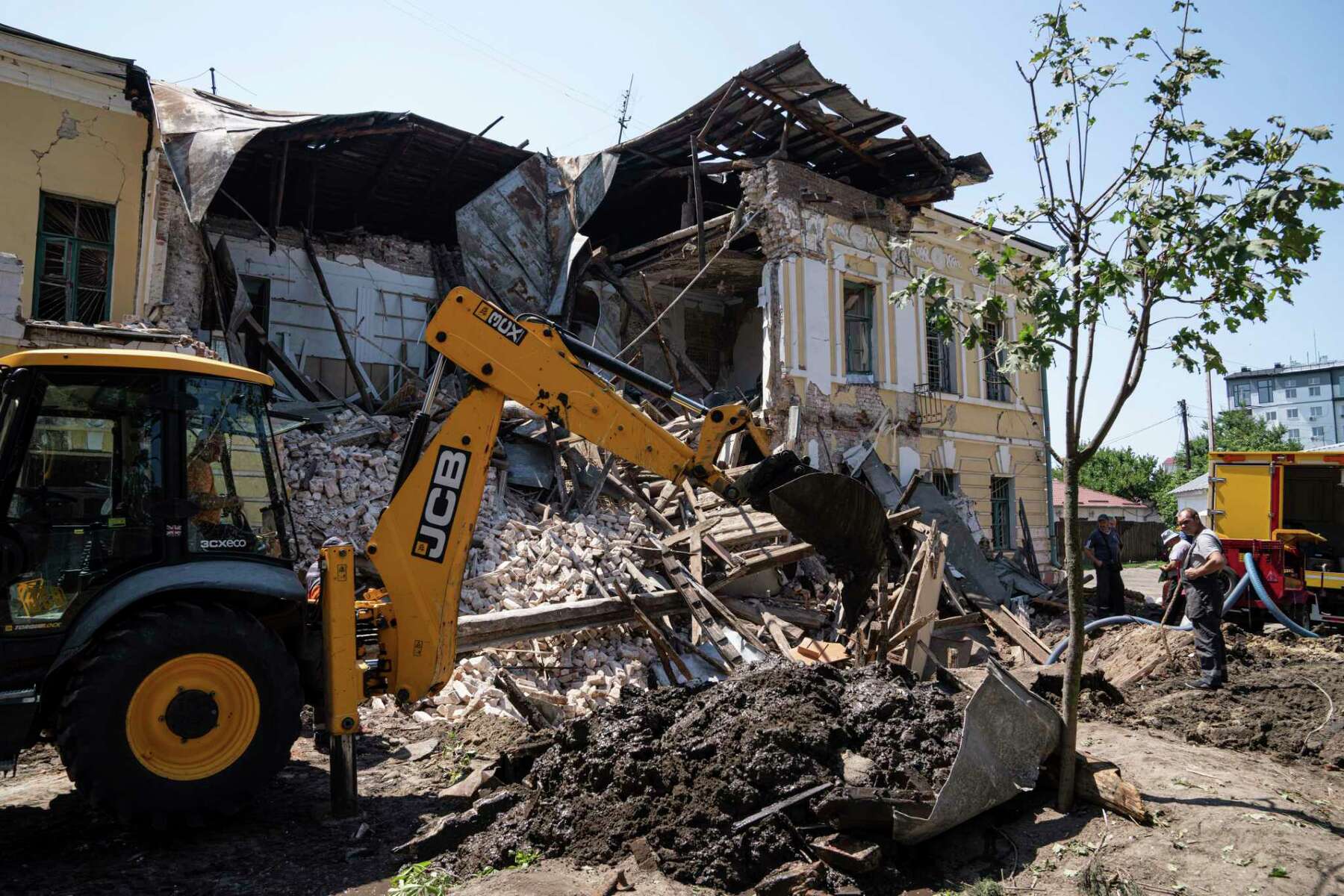 An excavator clear the rubble of military registration office destroyed by Russian attack in Kharkiv
