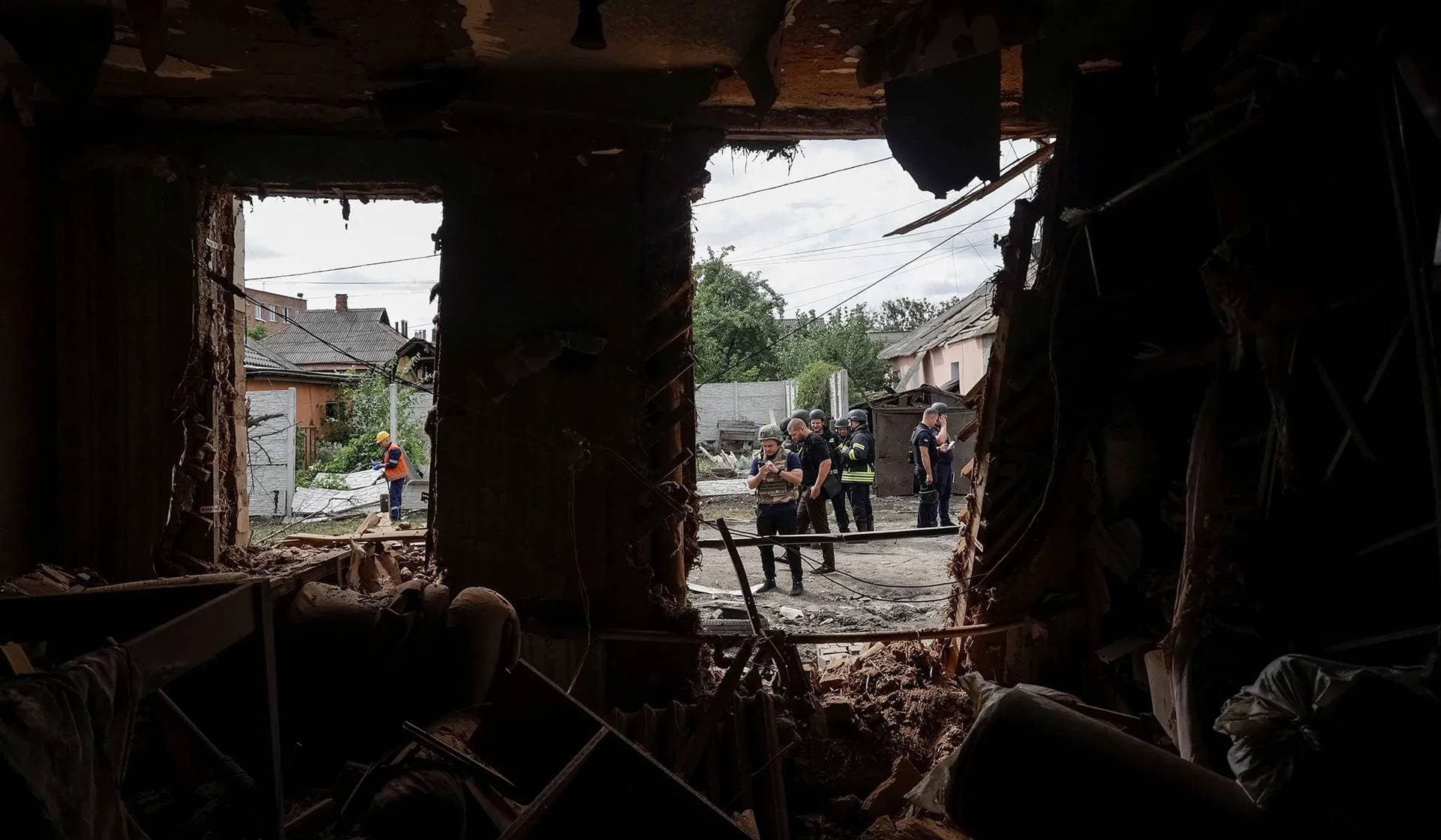 Rescuers work at a site of the house hit during a Russian drone strike in Kharkiv Region