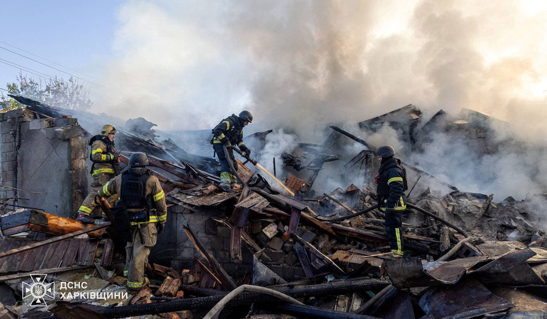 Firefighters work at the site of a private household hit during morning Russian drone strikes in Kharkiv